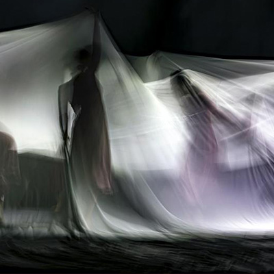  Photograph of two performers moving underneath flowing cloth by Hulki Okan Tabak