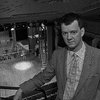 Black and White photograph of Tom Morris with the stage of the Bristol Old Vic behind and below him