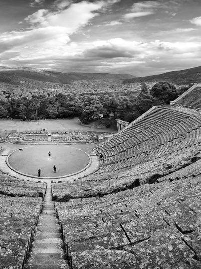 A black and white photo of the Greek theatre at Epidauros.
